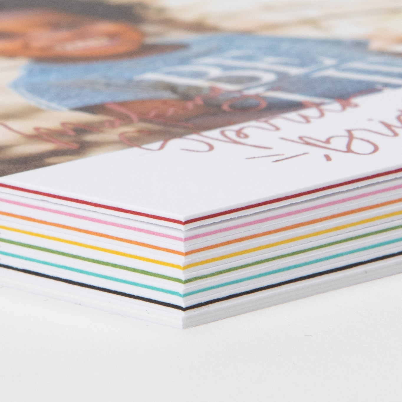 Close-up corner detail of a stack of Triple Thick Flat Cards showing all of the color insert options: white, black, teal, green, yellow, orange, pink, and red.