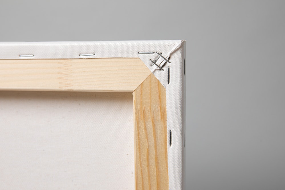 Close-up corner detail of Portrait Canvas print mounted and stapled to a Stretcher Frame, on gray background