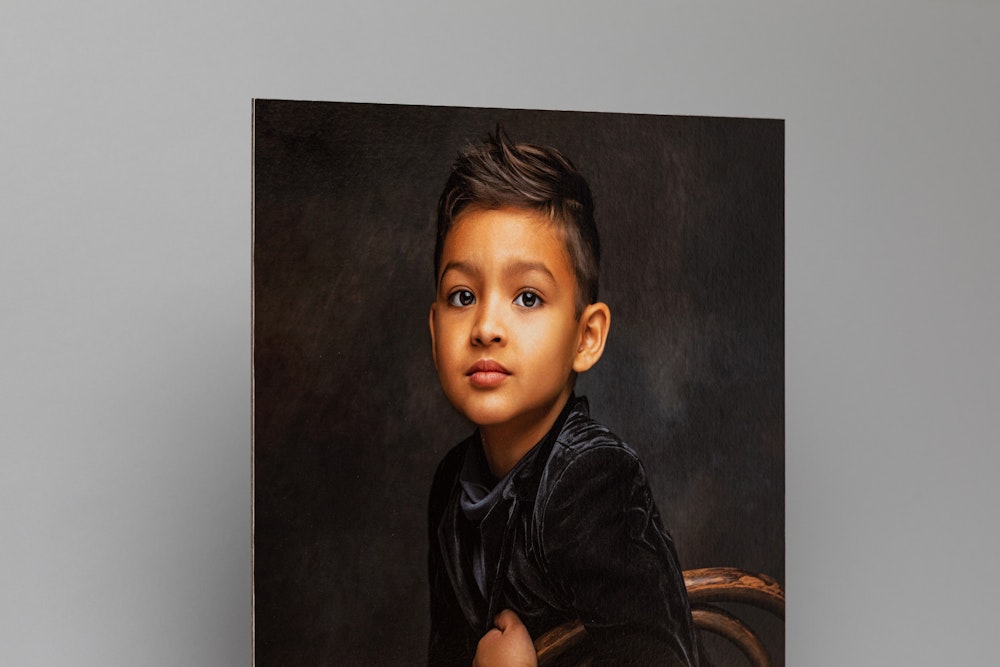Boy seated for a formal, professional studio portrait printed on Portrait Canvas mounted on Masonite, gray background