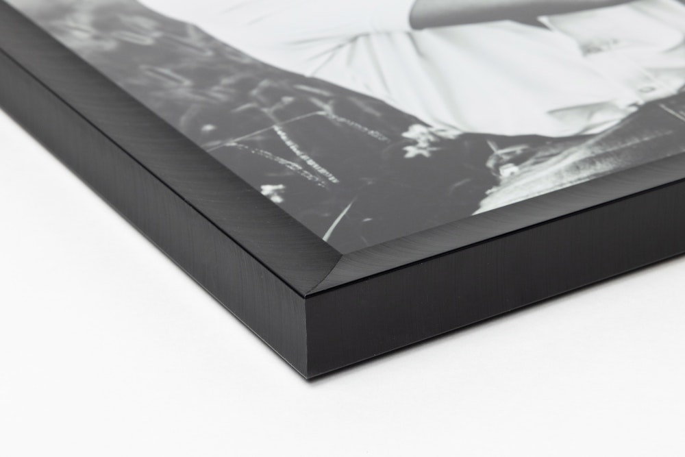 Close-up corner of a Jet Black Metal Framed Print moulding on a white background