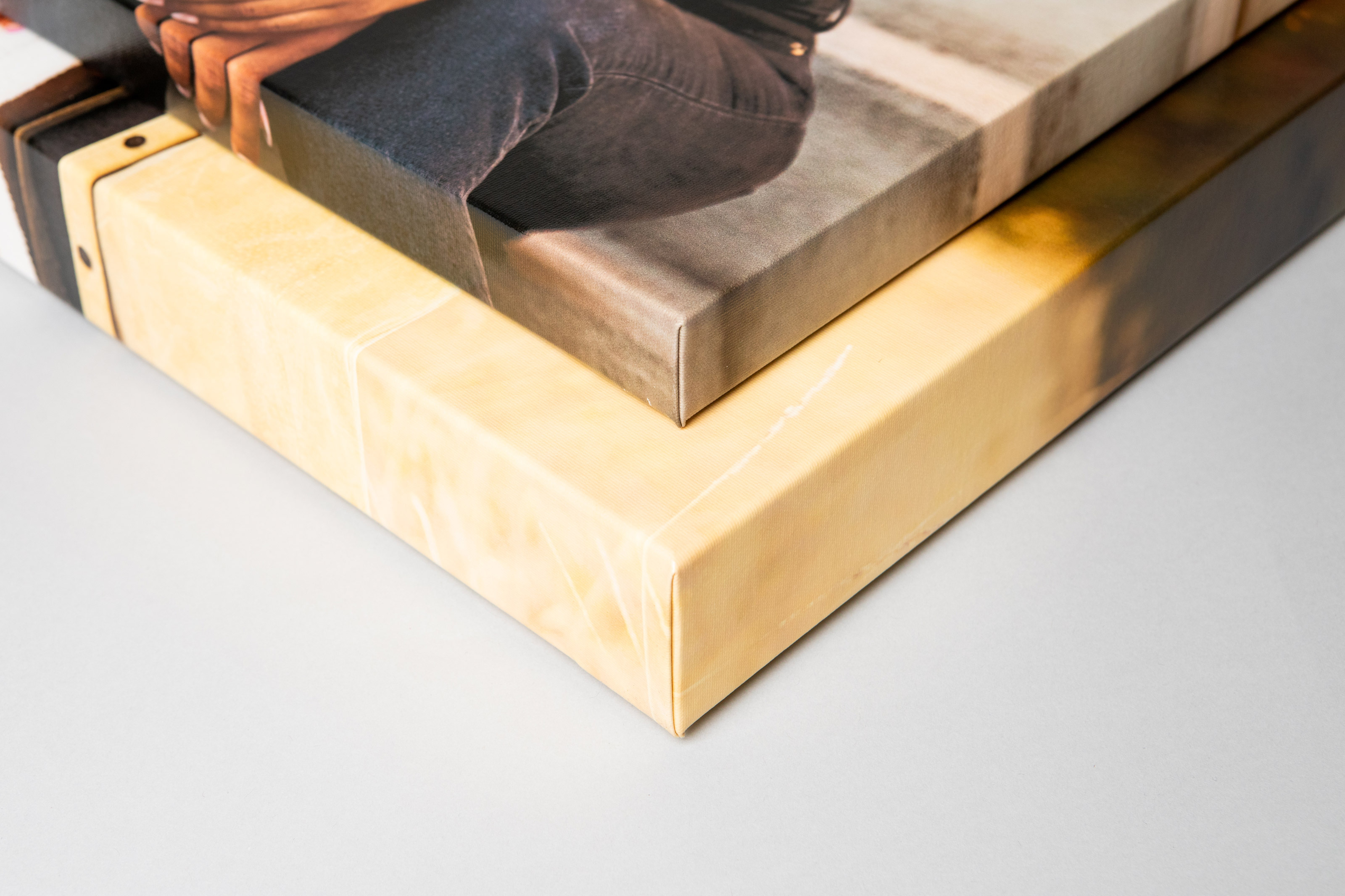 Two Premium Gallery Wraps, one 1½" and the other 2½" depth, stacked on each other, lying on a light gray background