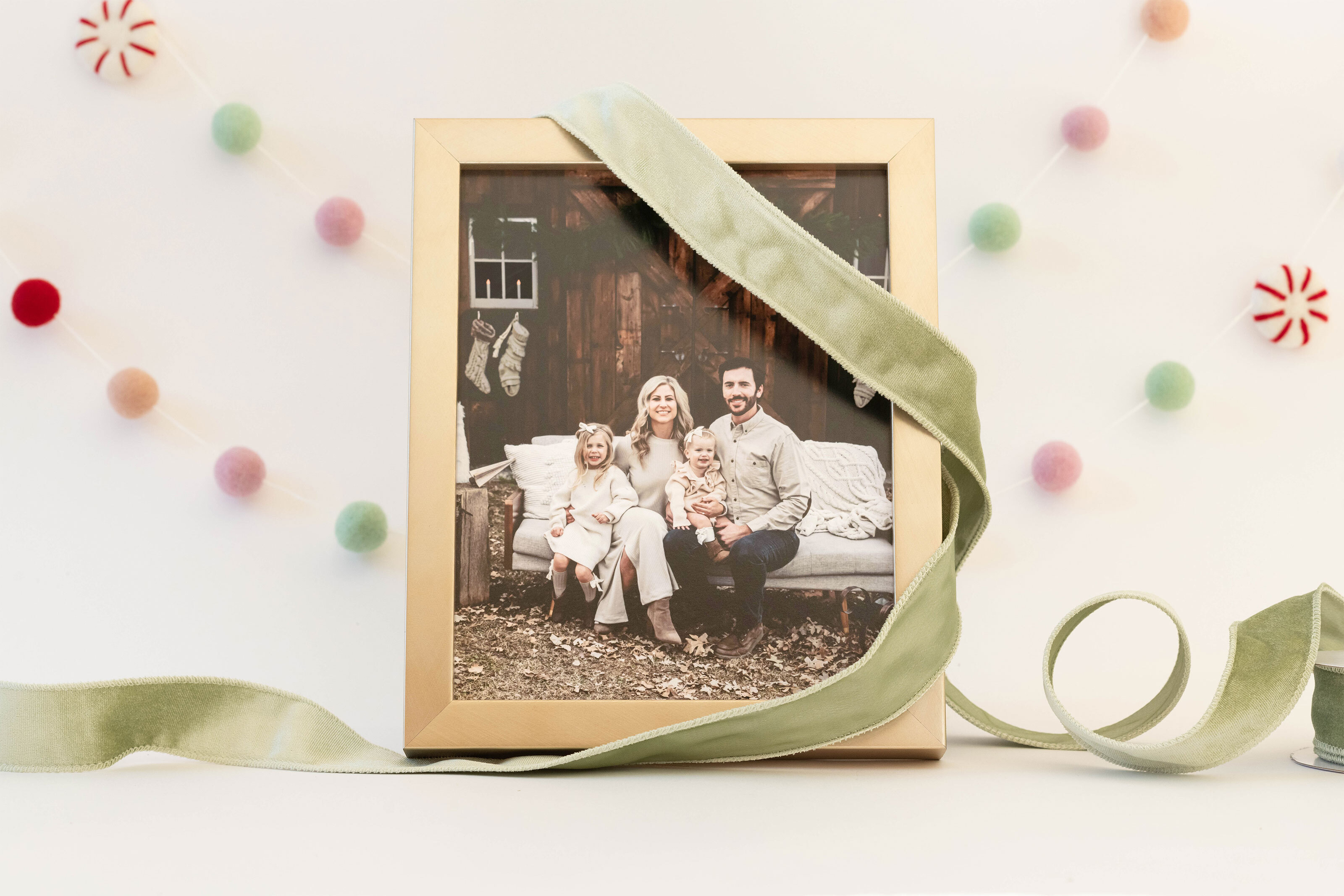 family portrait in a gold frame on a table surrounded by holiday themed decorations