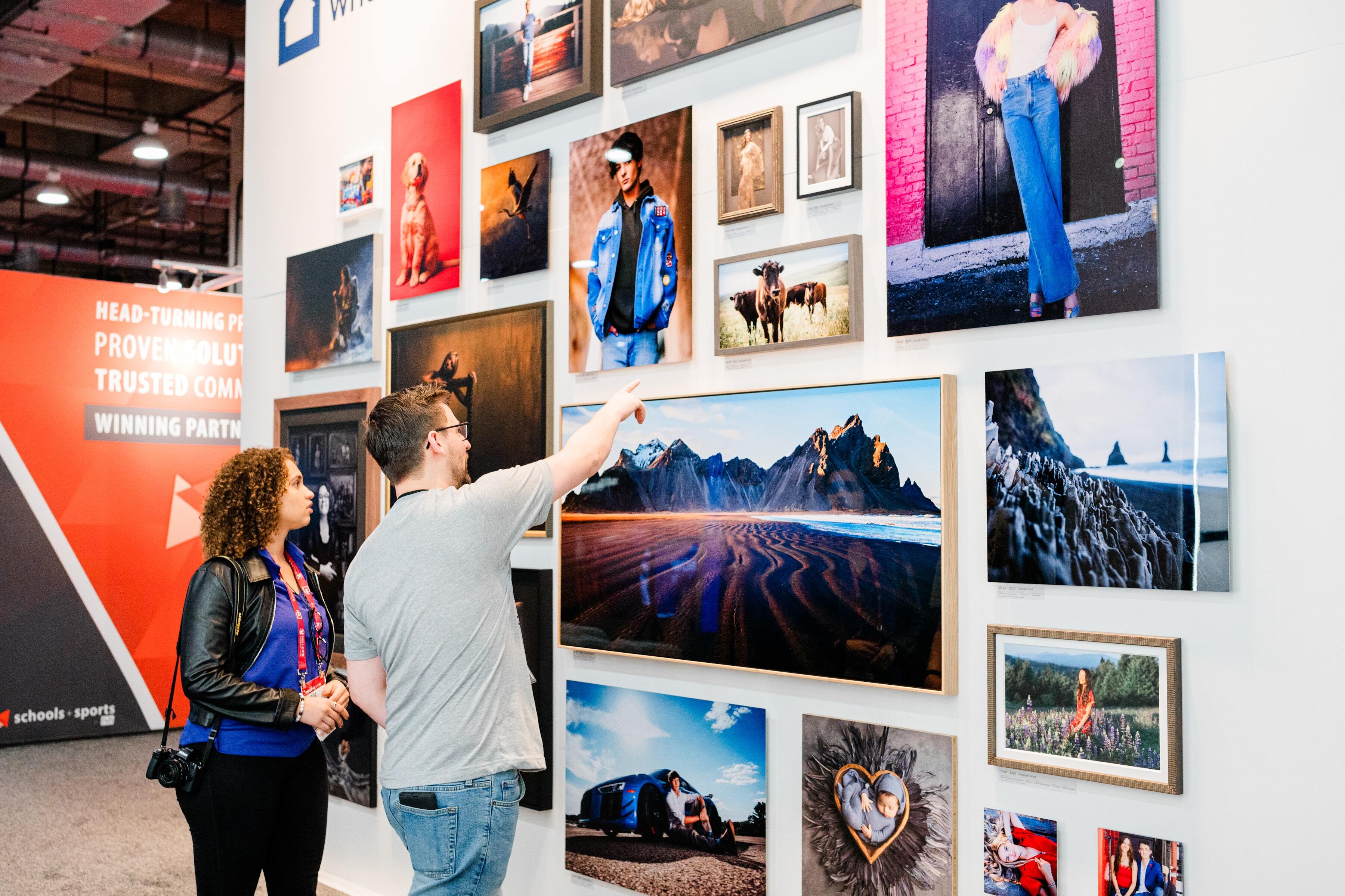 large collage of wall art products hung on a wall in a trade show