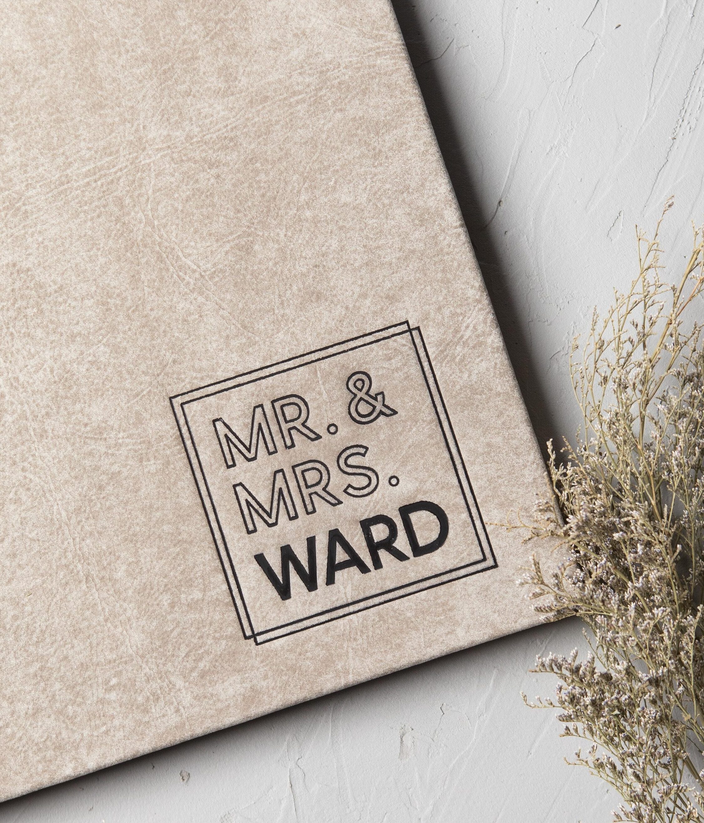 Close-up of custom debossing on a distressed leather wedding album cover personalized with the couple's name.