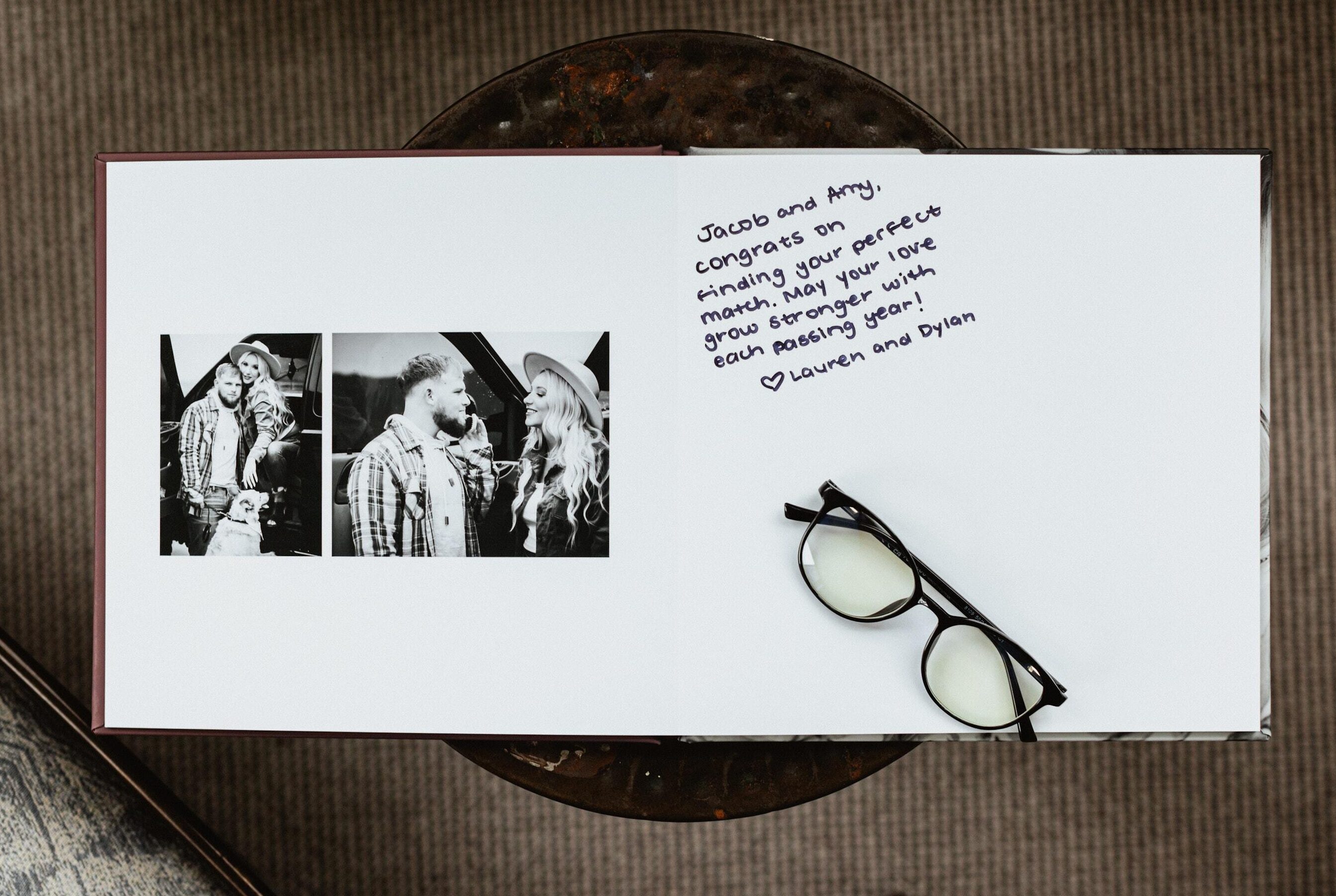Open layflat guest book with a two-photo black-and-white engagement spread on the left and a handwritten congratulations message on the right.