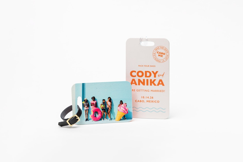 Colorful children's portrait printed on a small Bag Tag with a black leather strap, and a destination wedding design on a large Bag Tag with a clear plastic strap, standing on a white background.