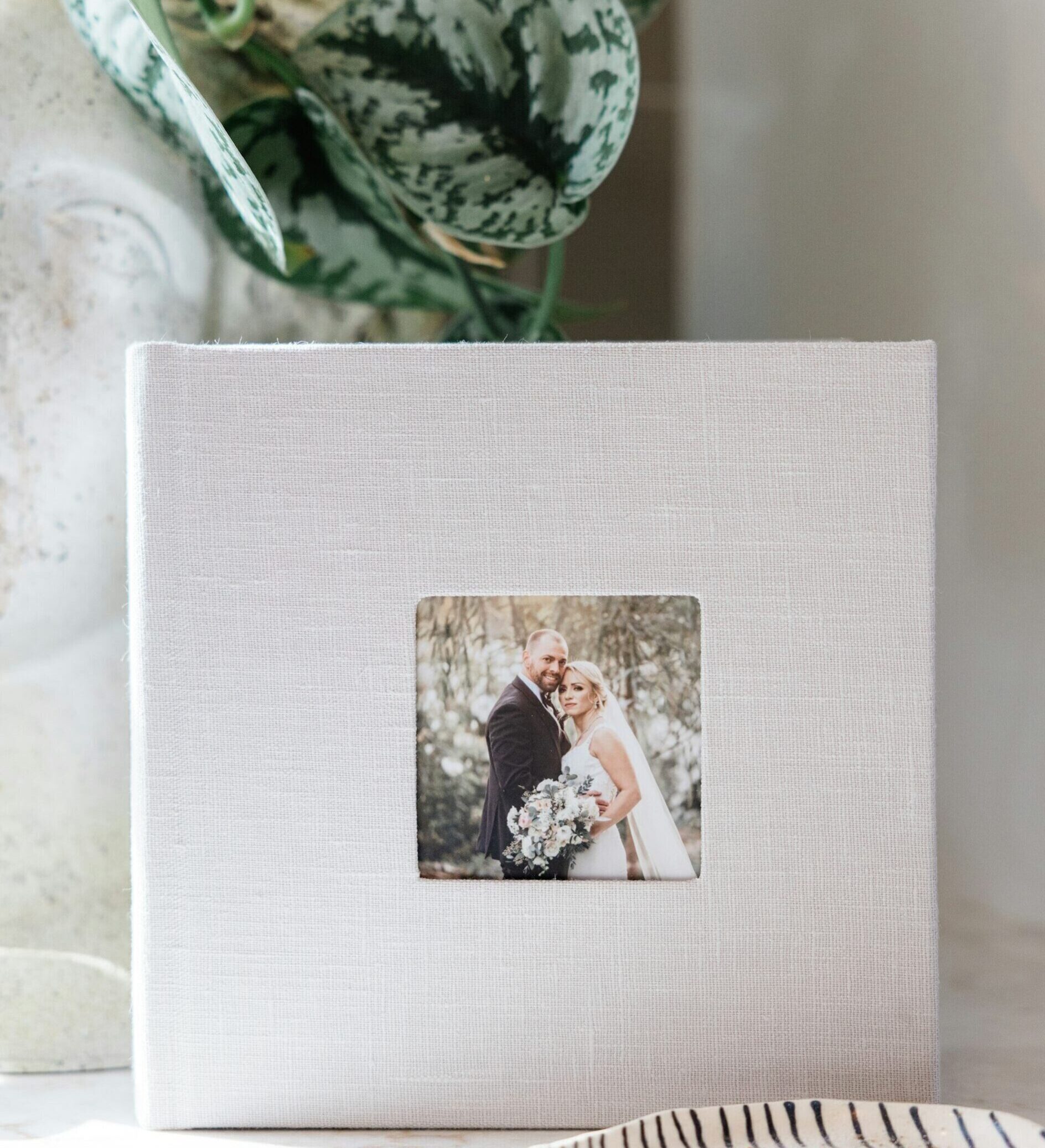WHCC wedding Photo Album with a Linen Cameo Cover sitting upright on a shelf.