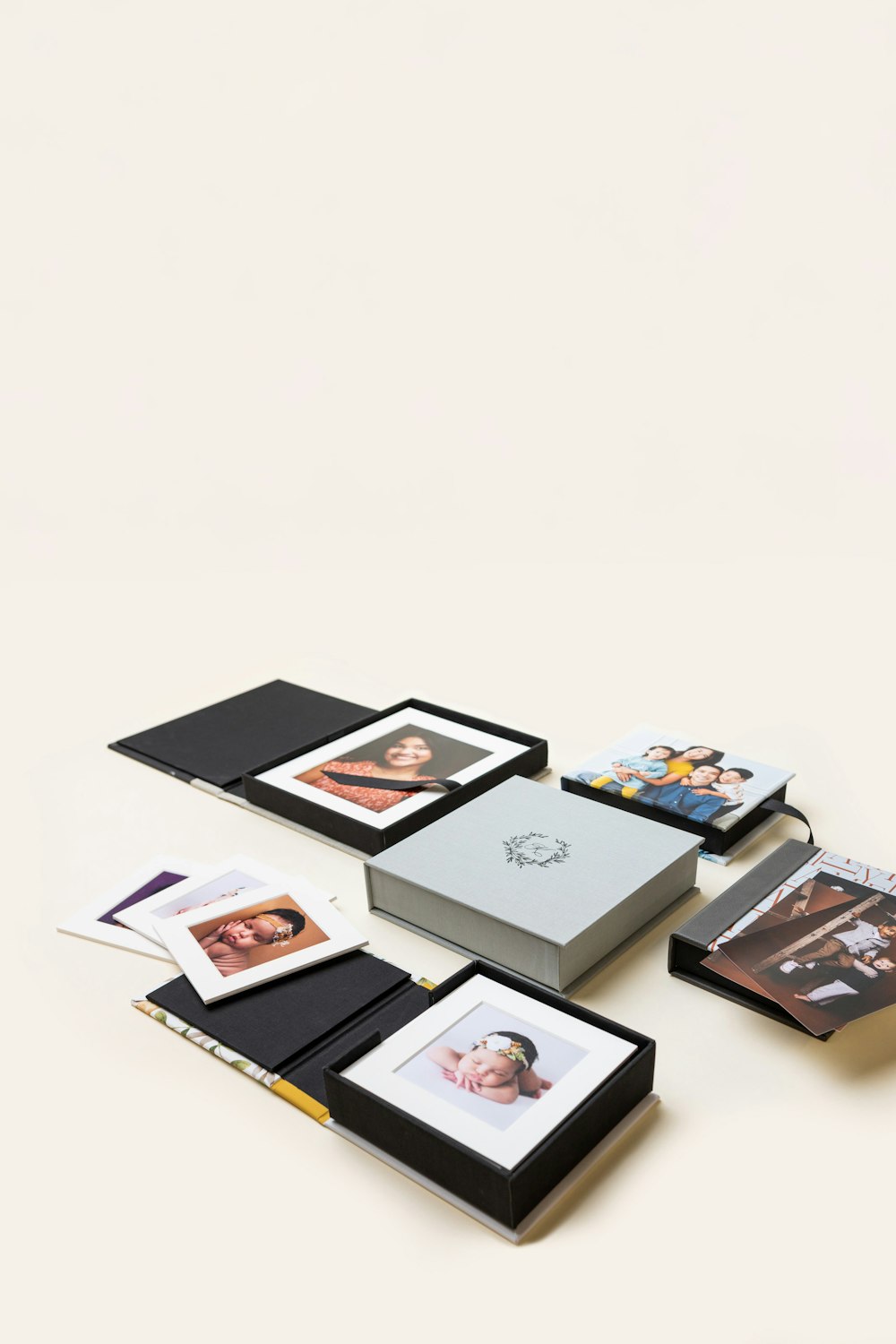 Several 3-Panel Print Boxes arranged on cream background, featuring debossed material and photo covers featuring imagery from various portrait photography sessions.