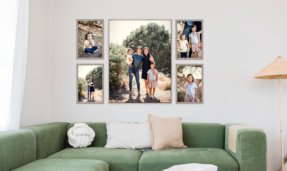 Large central Float Frame with two smaller Framed Prints on each side feature family portraits session photography hung over a green sectional couch with accent pillows and a tan wicker lamp