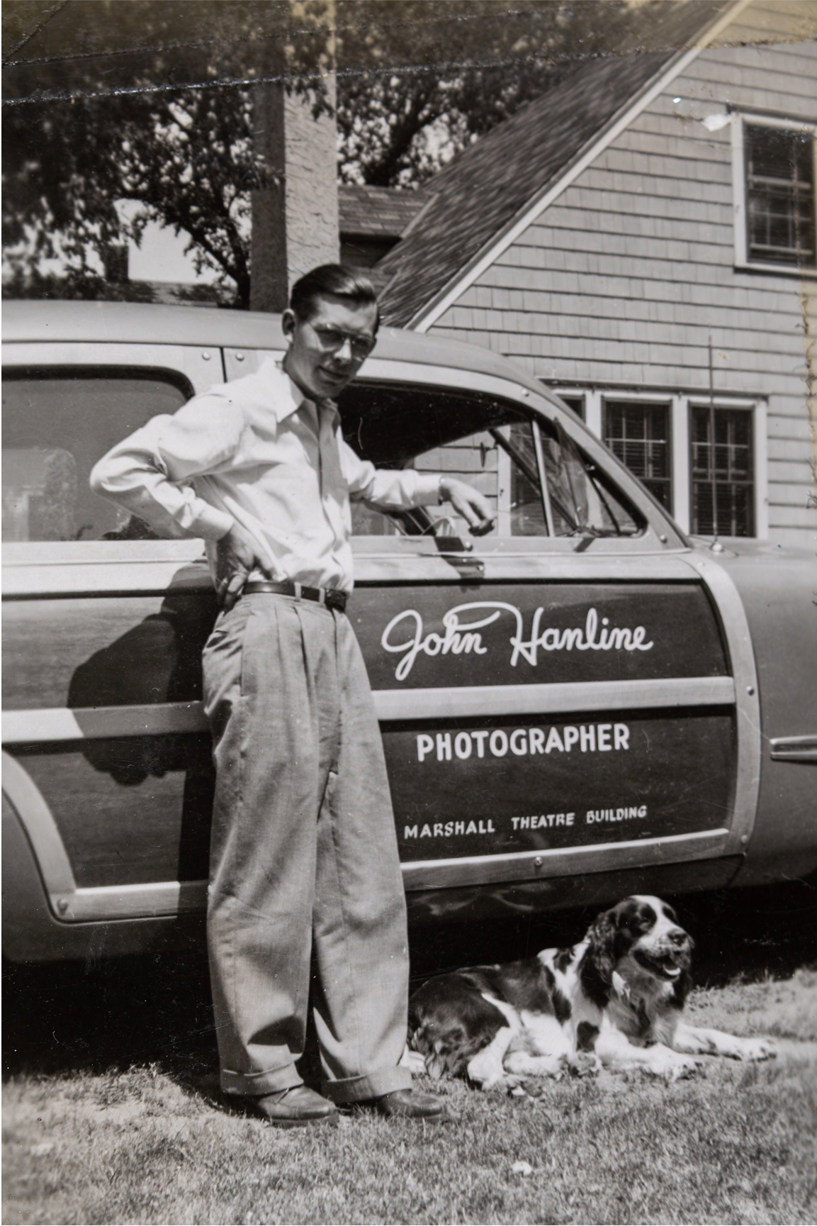 John Hanline standing in front of a branded station wagon in the 1950s