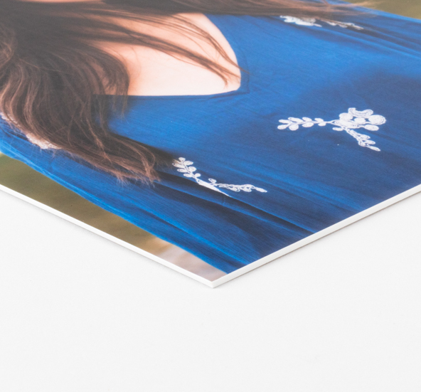 A person wearing a blue top with white floral embroidery is shown in a close-up photo print mounted on matboard