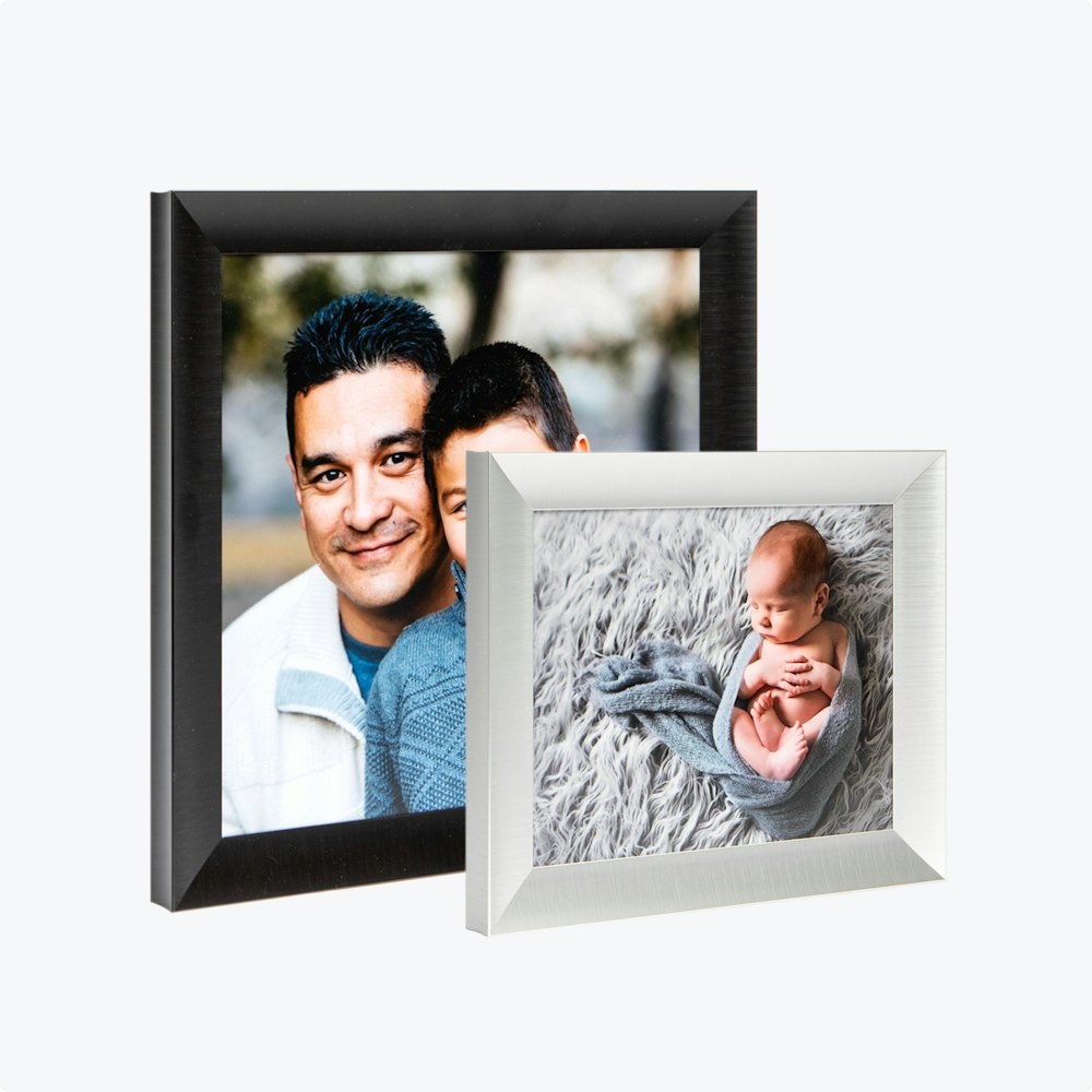 Two photographs in metal frames: one depicts a baby, while the other shows a man with his child.