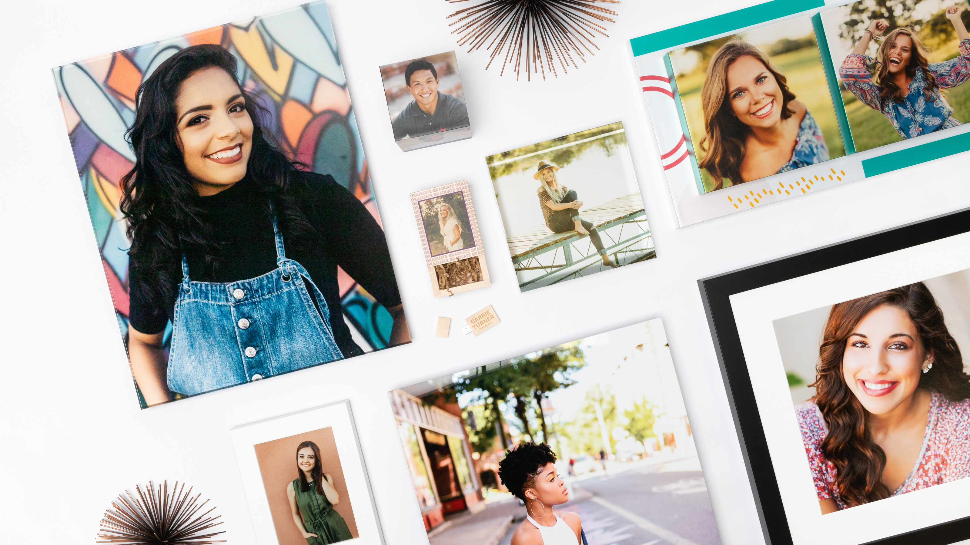 multiple pro portraits of high-school seniors in various photo prints and wall art products layed on a table