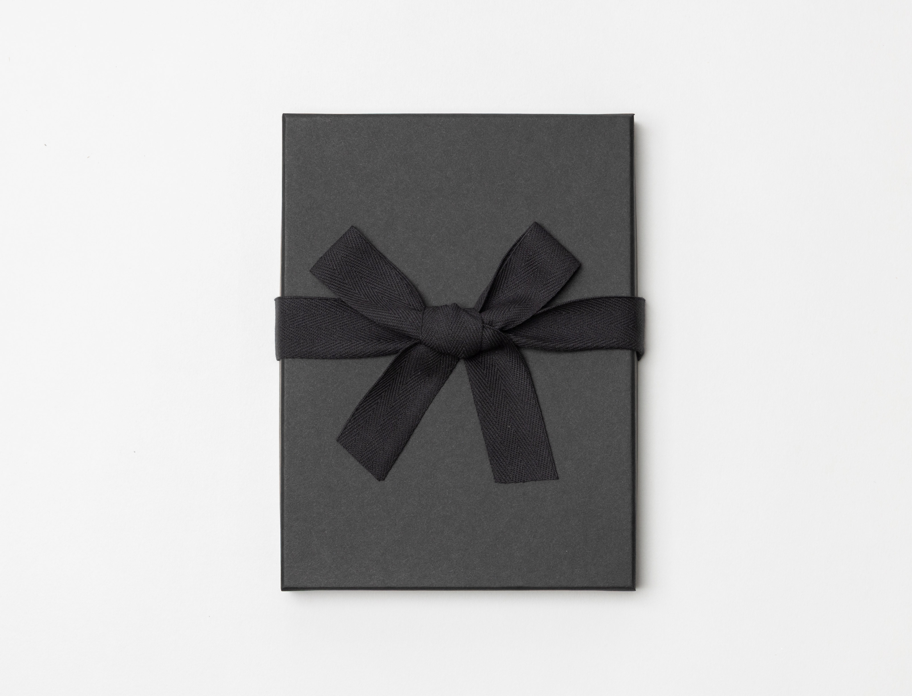 Charcoal Premium Packaging box with a black ribbon tied in a bow on a light gray background