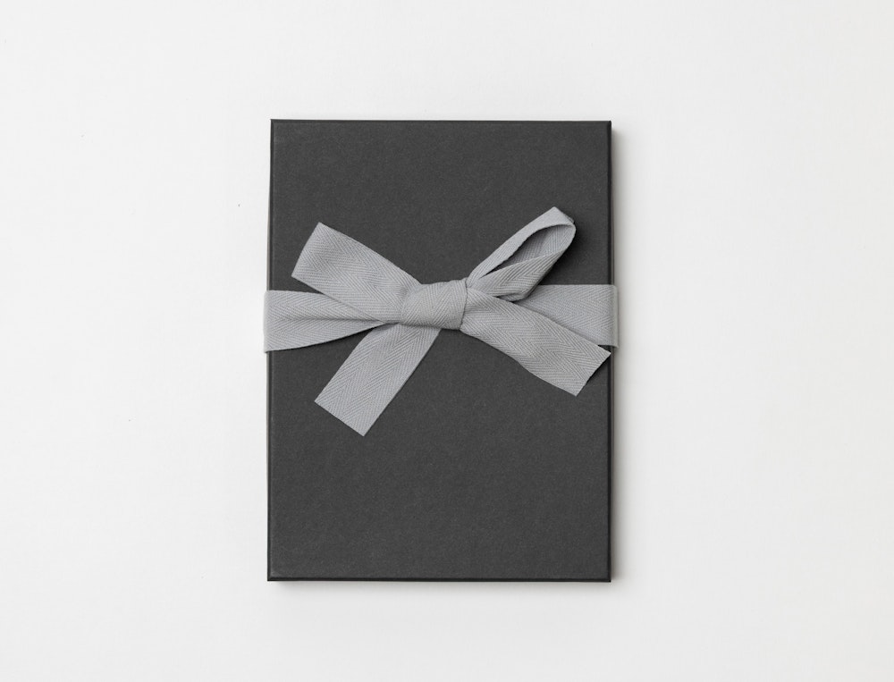 Charcoal Premium Packaging box with a gray ribbon tied in a bow on a light gray background